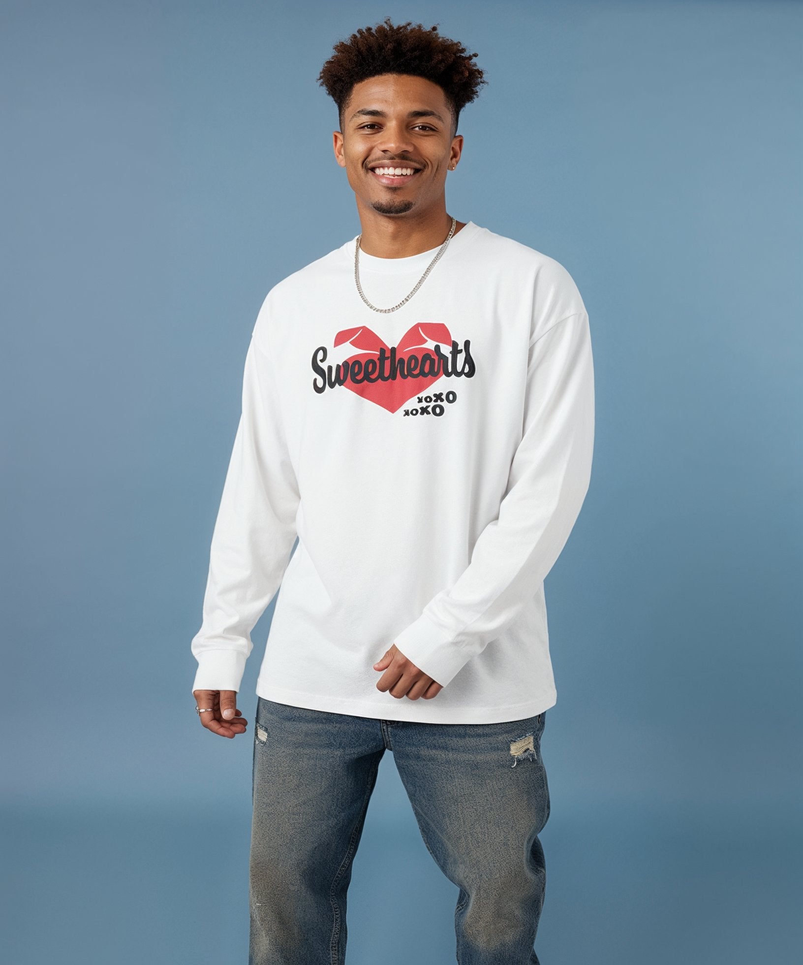 Man wearing a white long-sleeve shirt with a heart design and xoxo text on a blue background