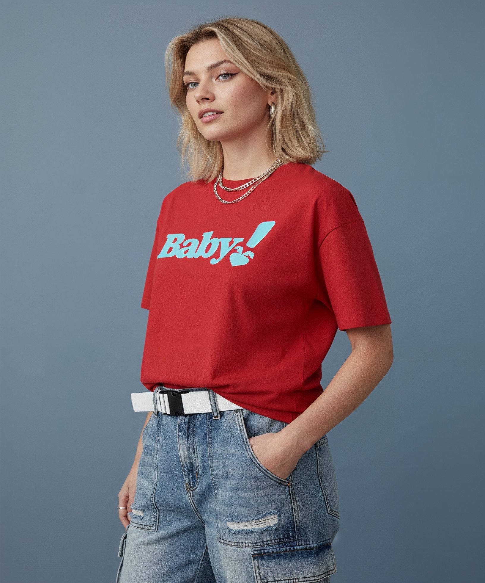 Woman wearing a red t-shirt with baby text and blue jeans on a blue background, side view
