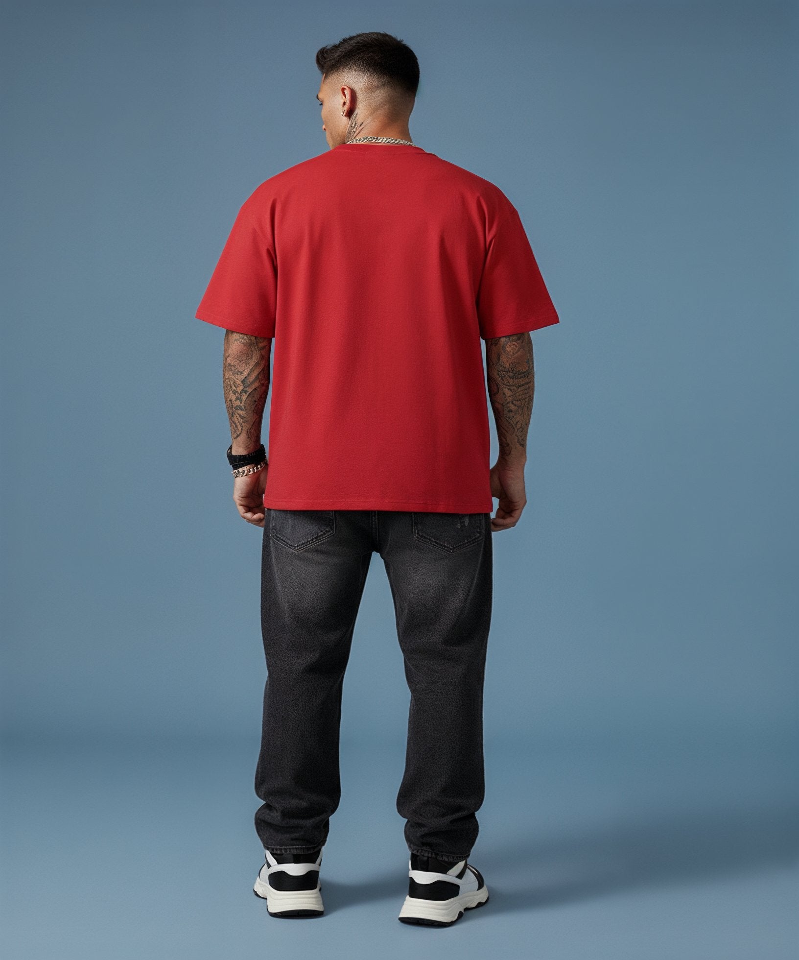 Person wearing a red t-shirt and black pants on a blue background