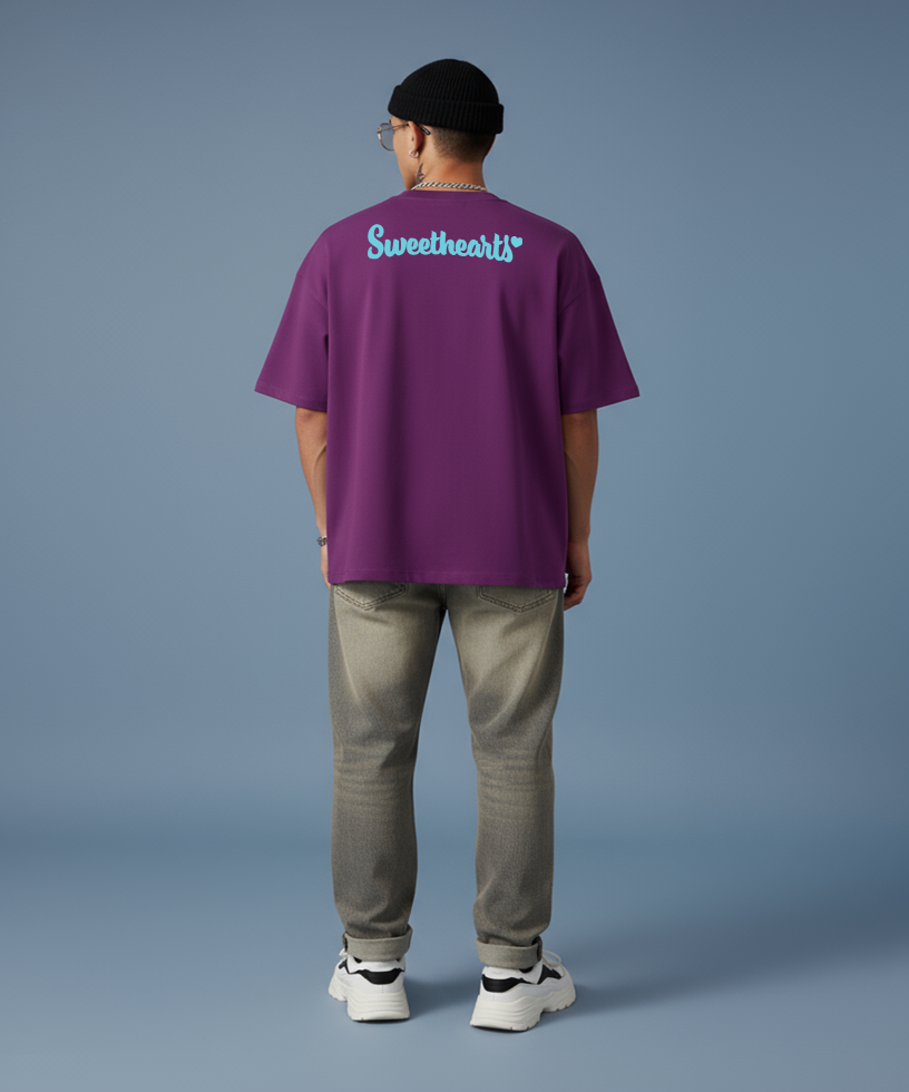 Person wearing a purple 'Sweethearts' t-shirt on a blue background, back shirt view