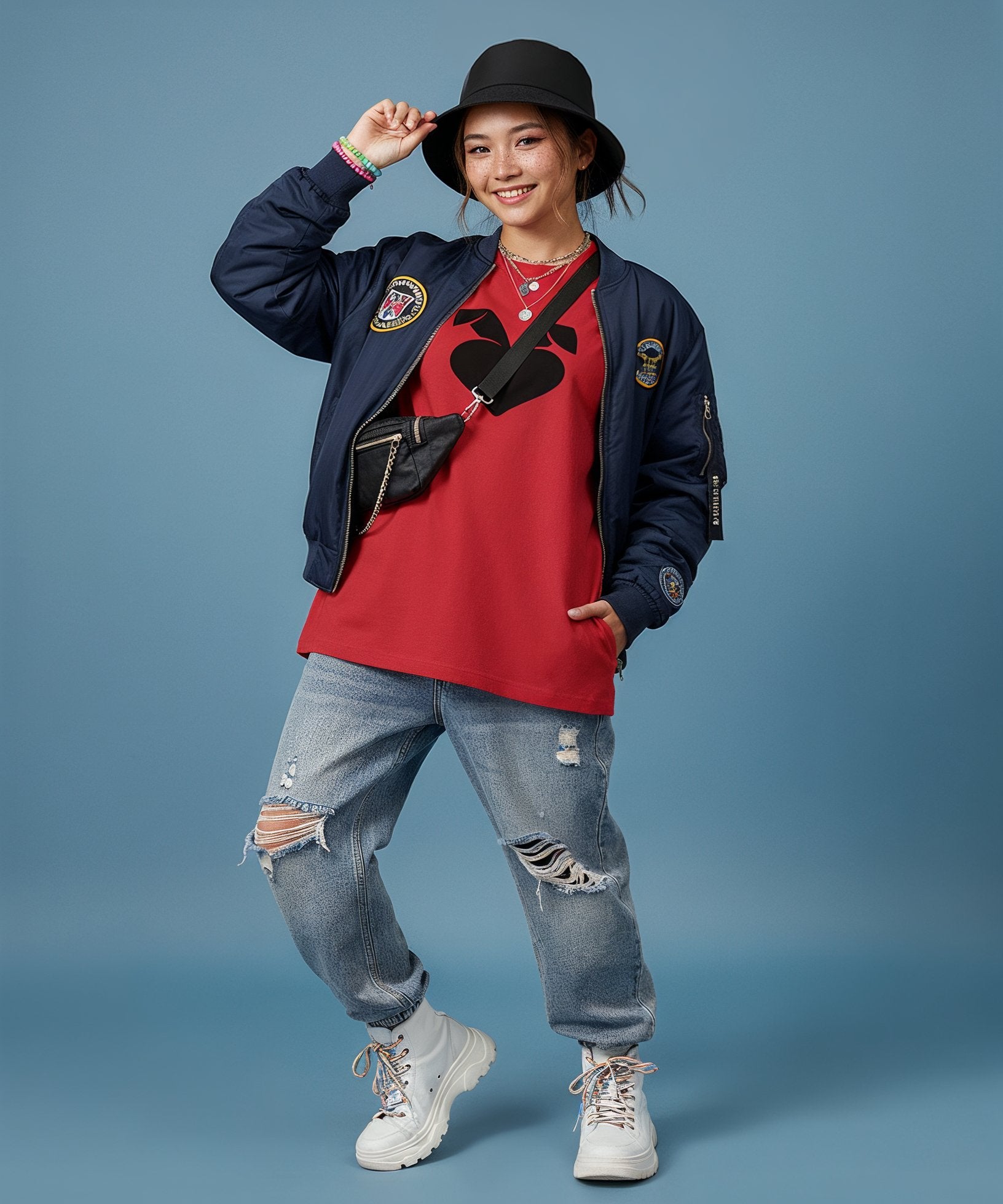 female wearing a red shirt sweethearts logo, blue jacket, and jeans with a black hat on a blue background