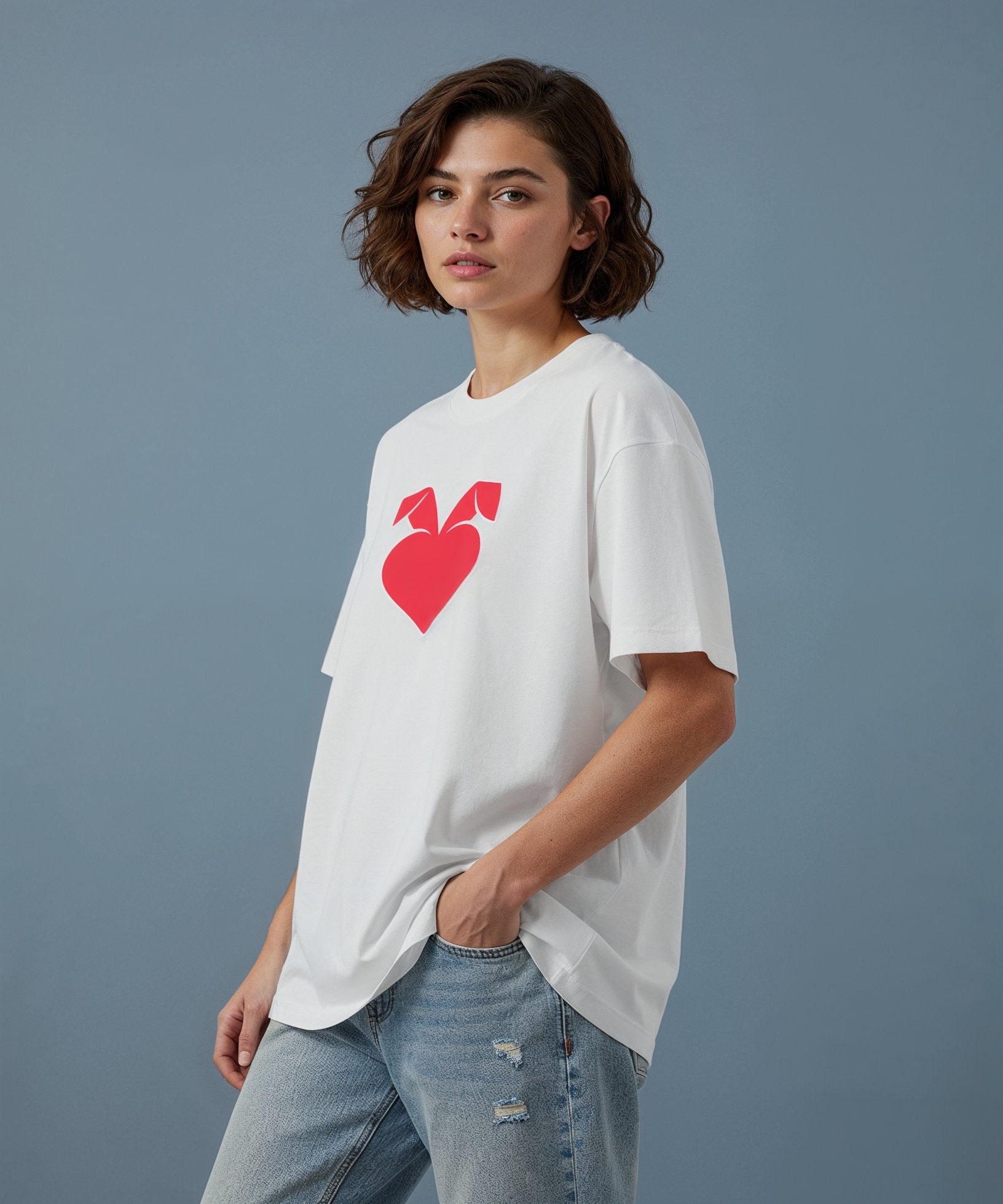 female model wearing white t-shirt with a red sweethearts logo heart design on a blue background, side view