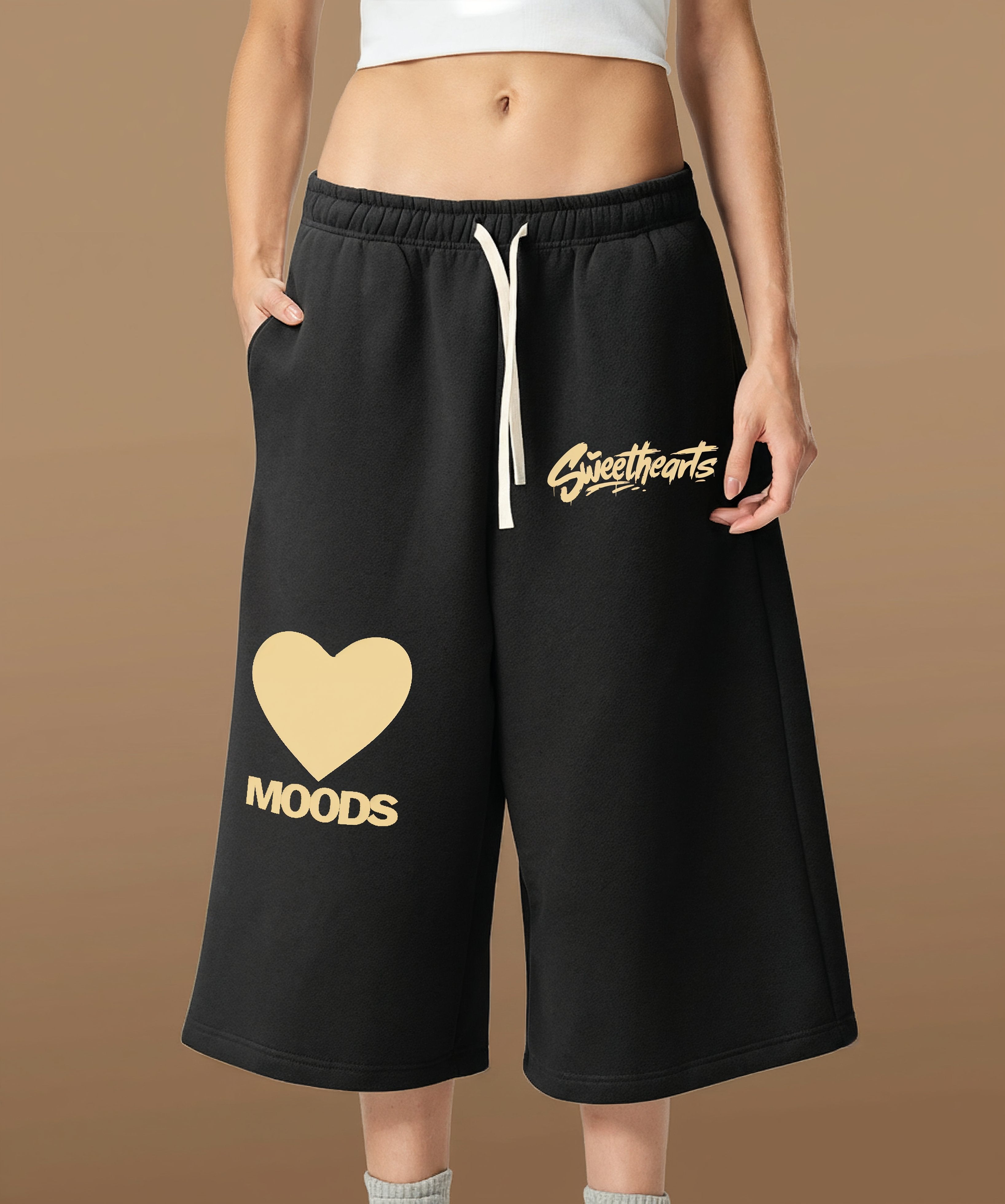 Sweethearts graffiti text and heart logo printed on black shorts from Moods Drop, female front view