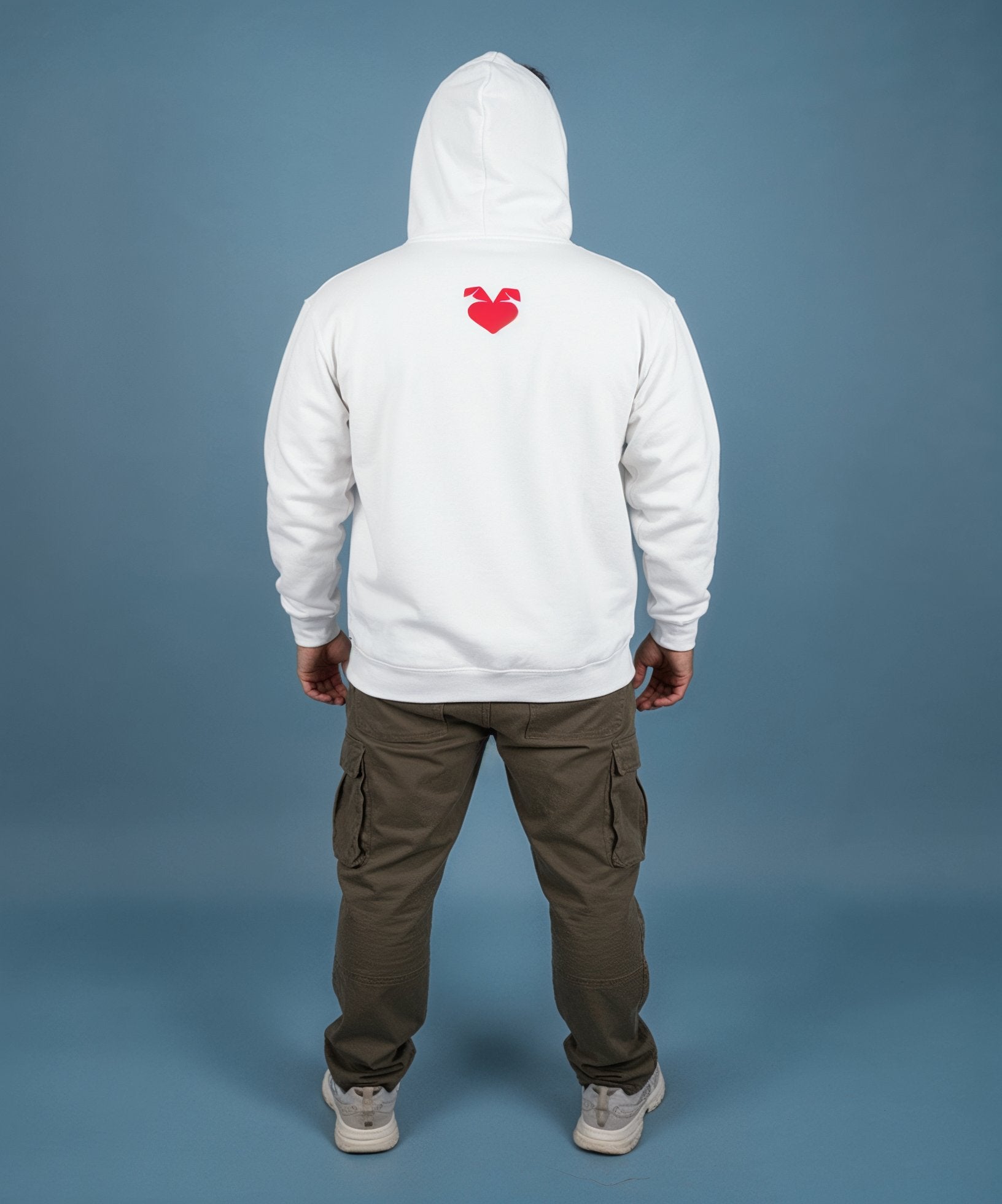 Man wearing a white hoodie with a sweethearts red heart logo and xoxo design and text on a blue background, back view