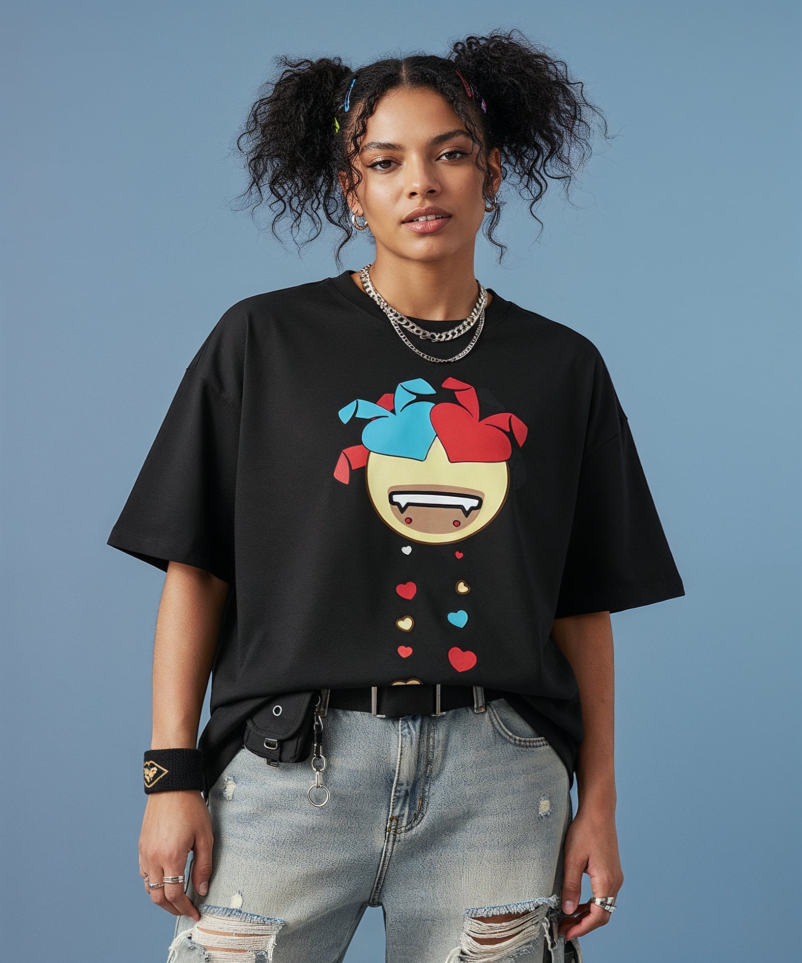 female wearing a black t-shirt with a colorful sweethearts emoji design on a blue background