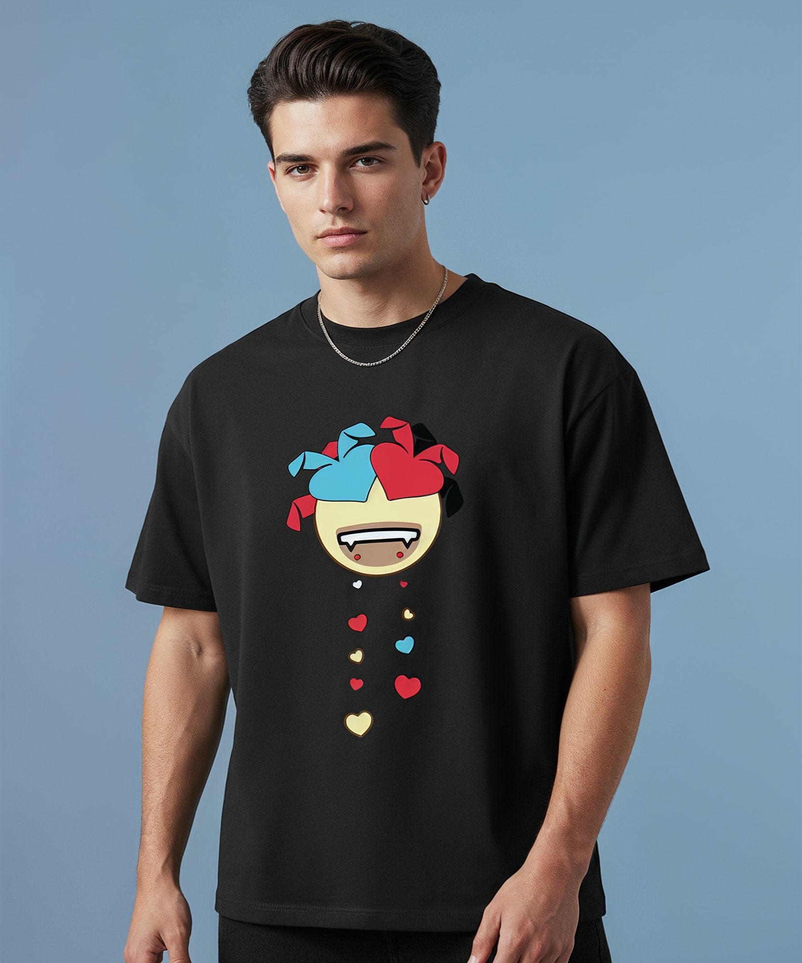 Man wearing a black t-shirt with a colorful sweethearts emoji design on a blue background