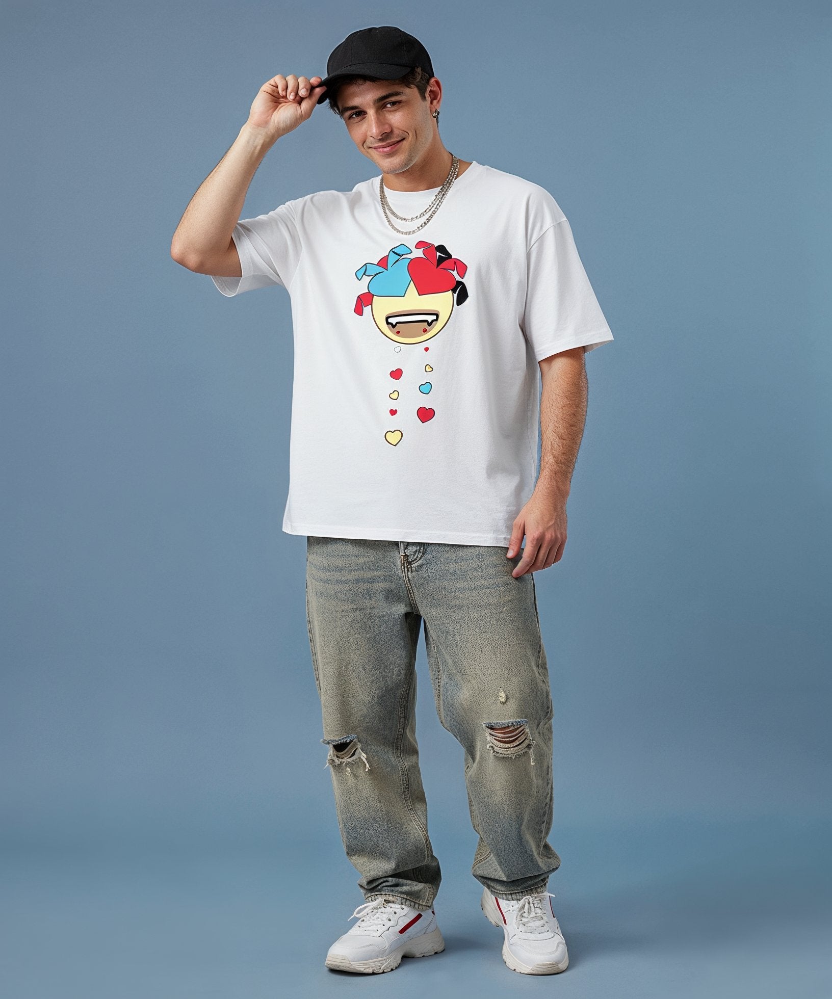 male wearing a sweethearts white t-shirt with a colorful graphic design and ripped jeans on a blue background. front view