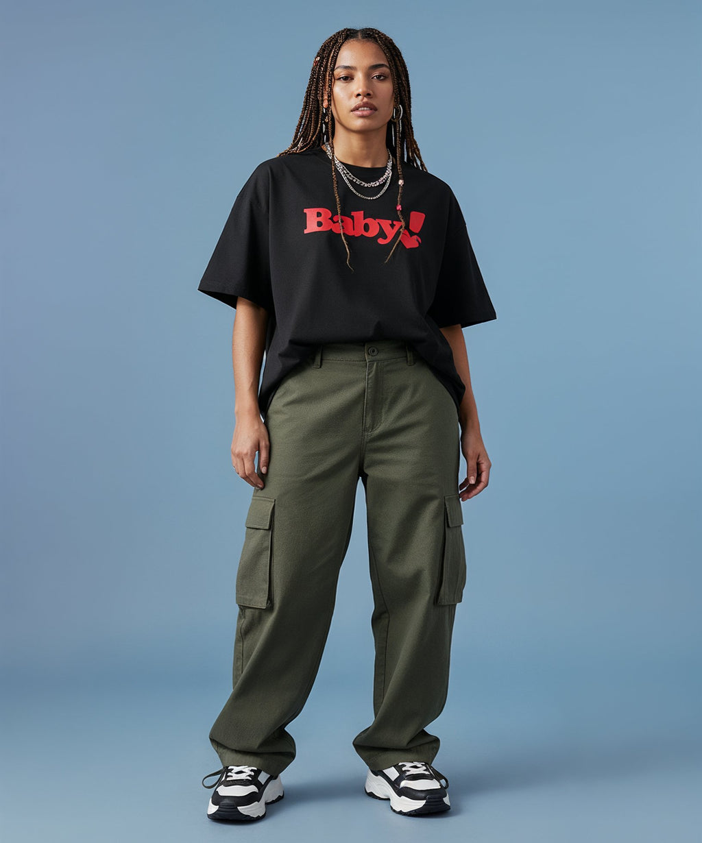 female wearing a black t-shirt with sweethearts red "baby" text, front view,  and green cargo pants on a blue background