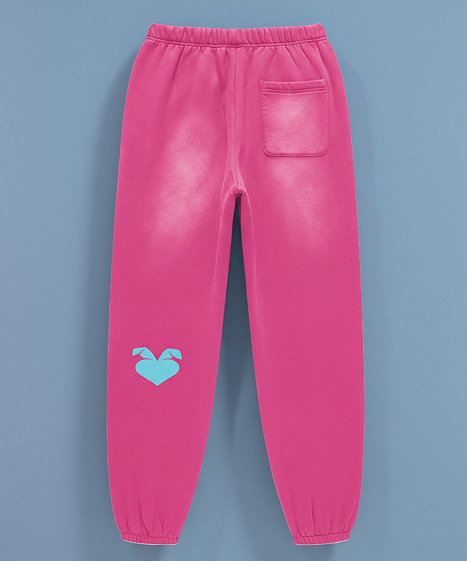 Pink sweatpants with sweethearts  'Baby!' text on a blue background, back view