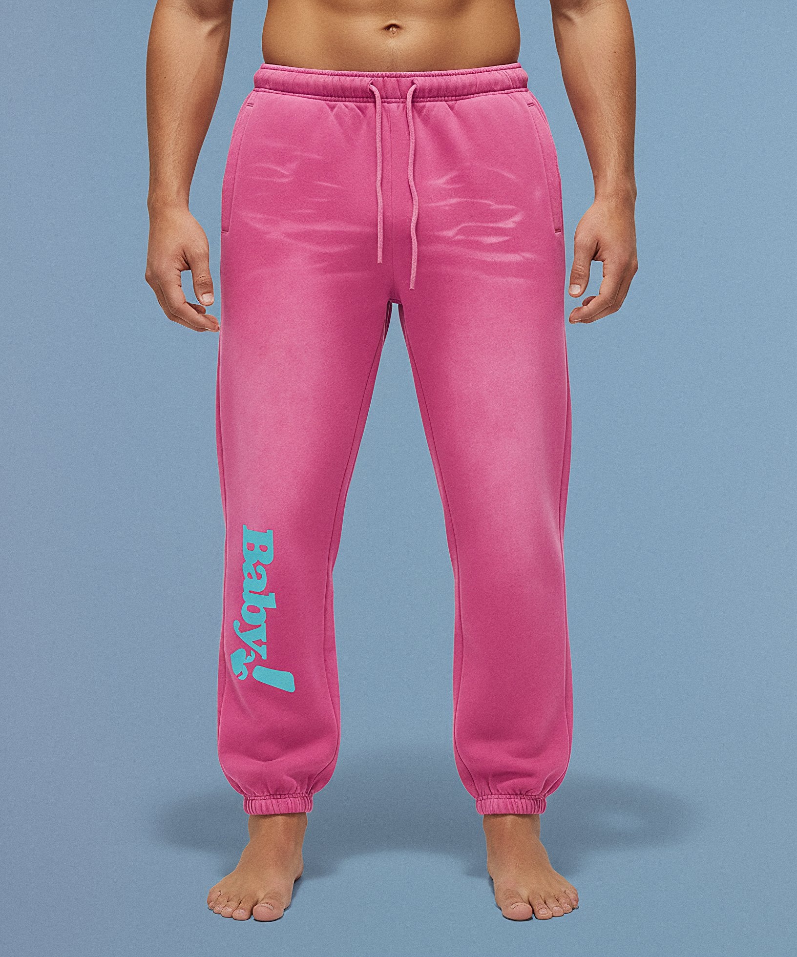 Pink sweatpants with sweethearts  'Baby!' text on a blue background, male front view