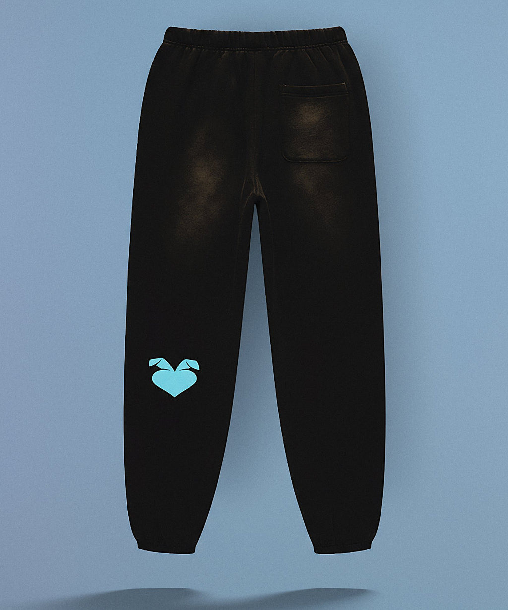 Black sweatpants with sweethearts 'Baby!' text on a gray background, back view