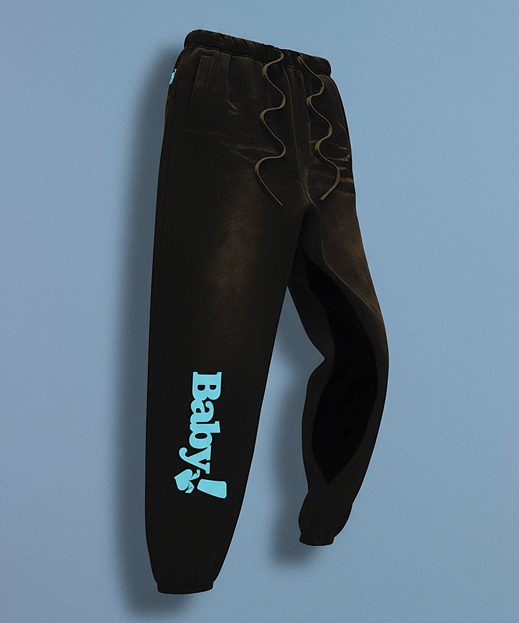 Black sweatpants with sweethearts 'Baby!' text on a gray background, side view