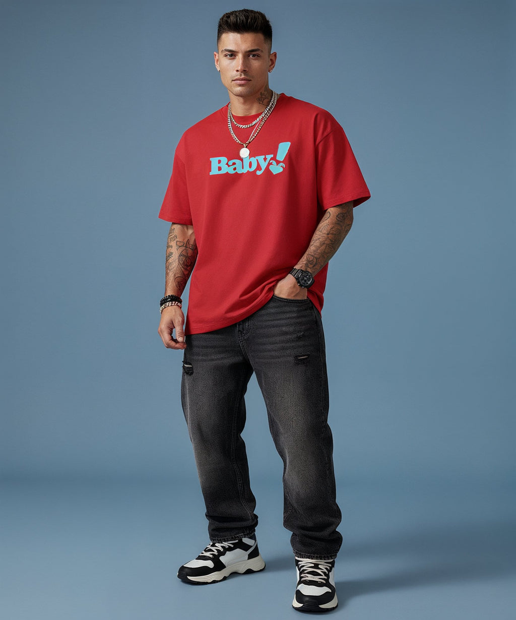 Man wearing a red t-shirt with 'Baby!' text, black jeans, and black and white sneakers on a blue background