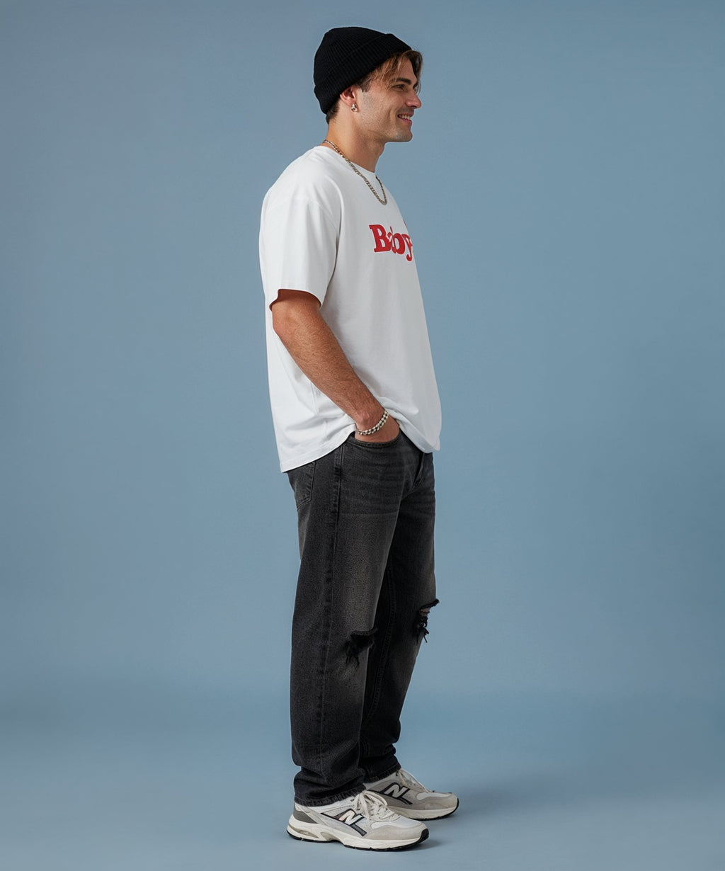 male wearing a white t-shirt with a red logo and dark pants on a blue background