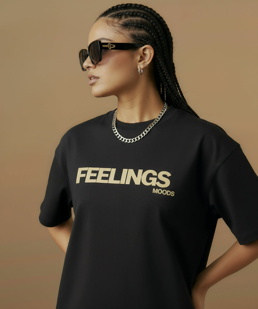 female model wearing a black t-shirt with  sweethearts brand 'FEELINGS MOODS' text on a brown background. angled left