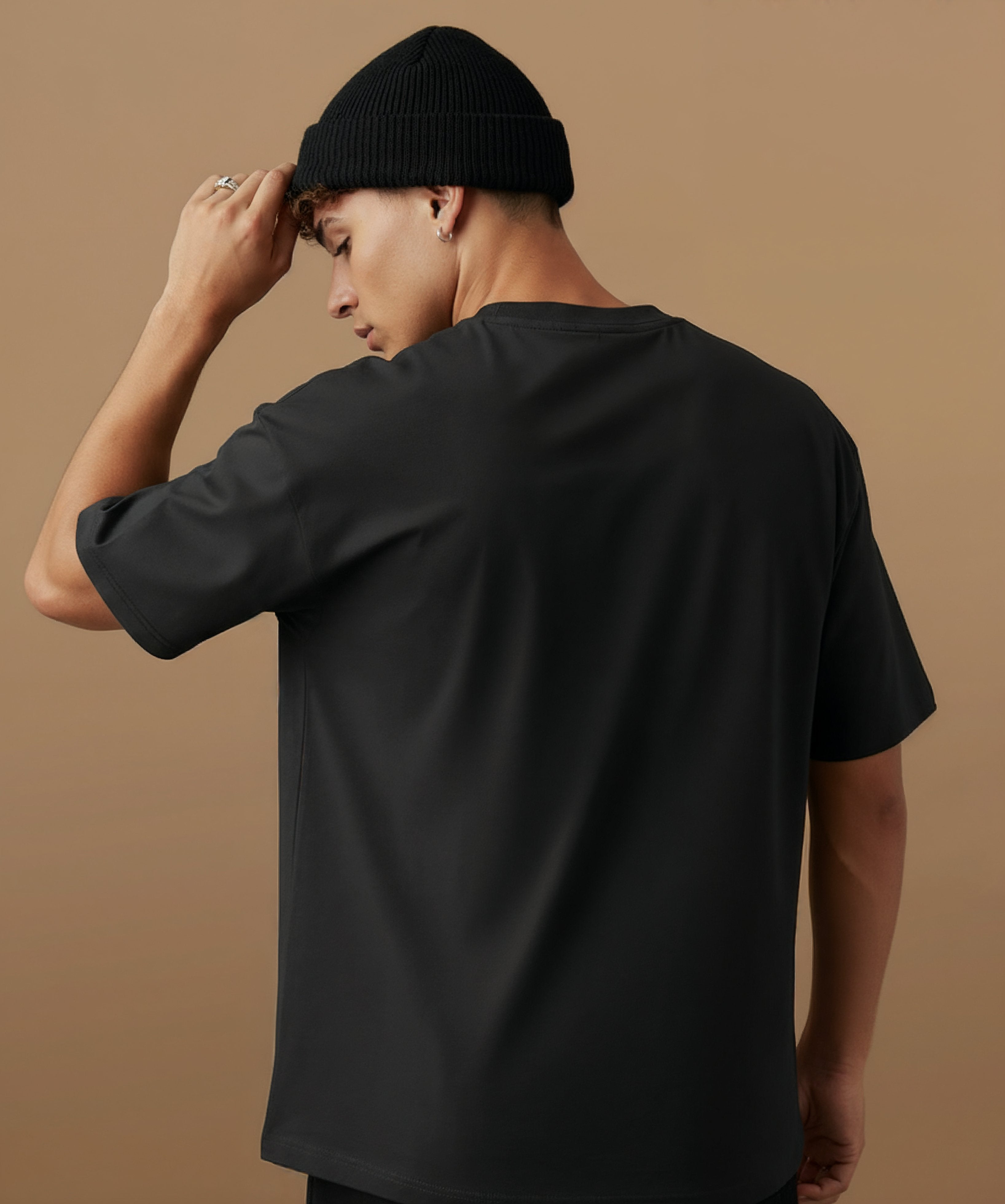 male model wearing a black t-shirt with  sweethearts brand 'FEELINGS MOODS' text on a brown background. back of shirt