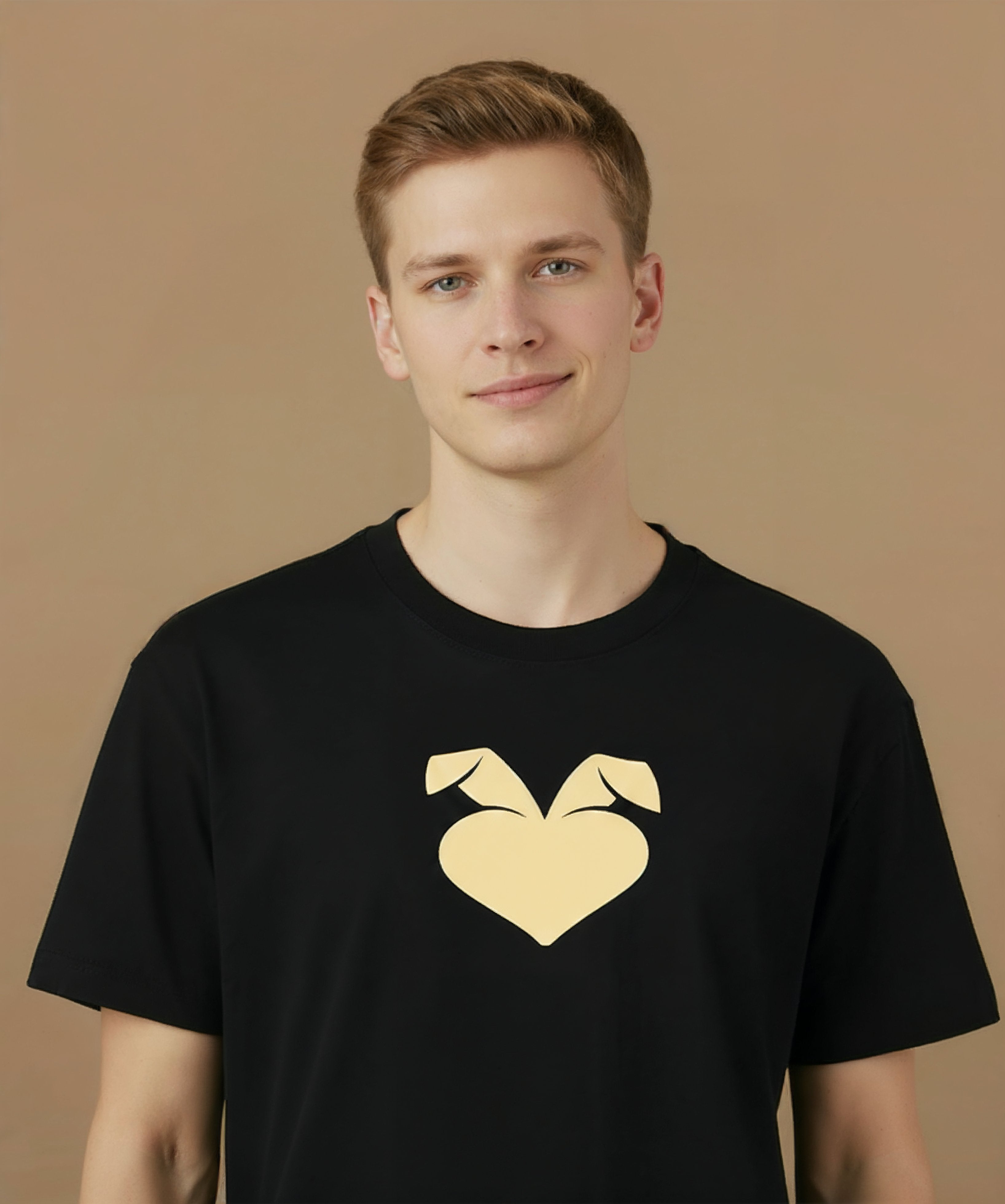 a male wearing a black sweethearts mood edition logo t-shirt with a gold heart design on a brown background