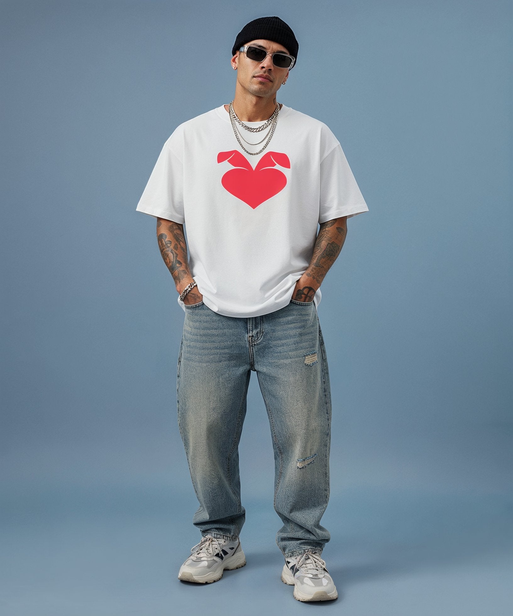 male model wearing white t-shirt with a red sweethearts logo heart design on a blue background, front view