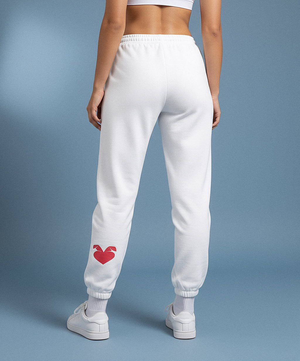 white sweatpants with a red heart design on the back, worn by a person against a blue background. back view
