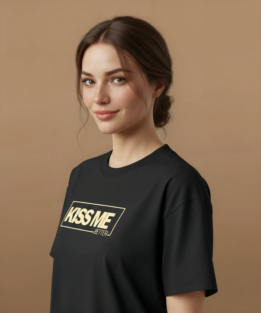 a female wearing a black t-shirt with 'KISS ME BETTER' text on a brown background, angled left