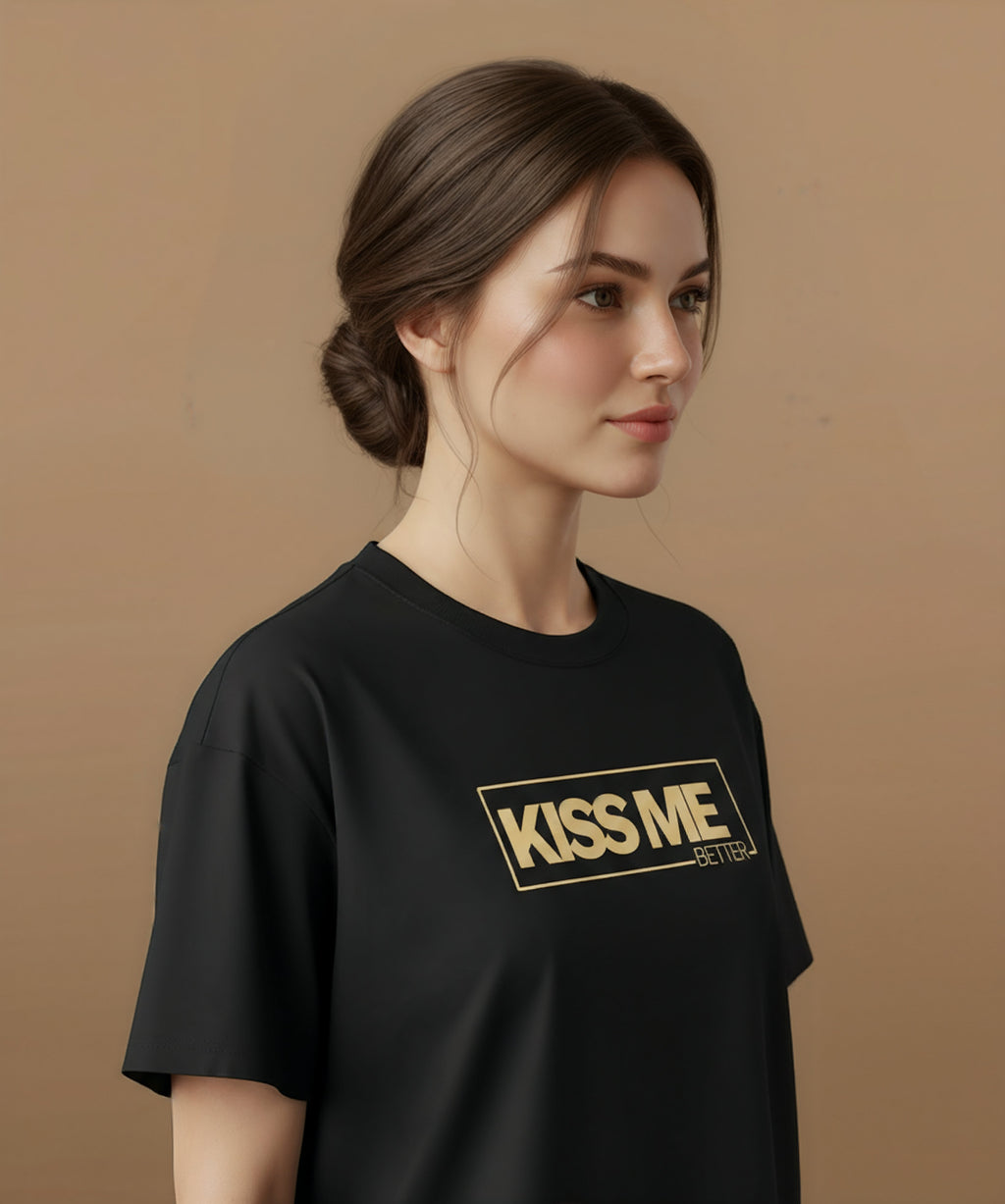 a female wearing a black t-shirt with 'KISS ME BETTER' text on a brown background, angled right