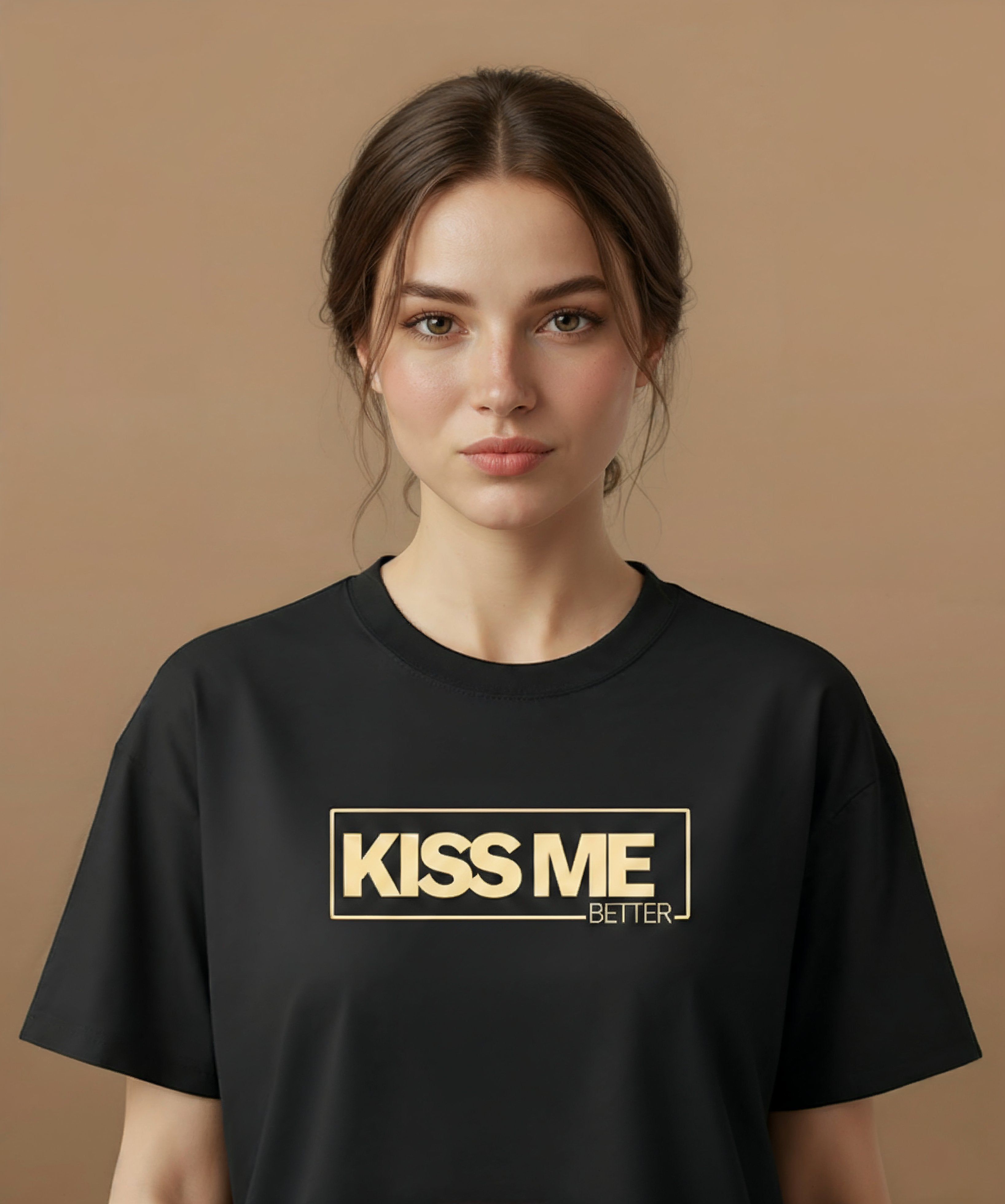 a female wearing a black t-shirt with 'KISS ME BETTER' text on a brown background