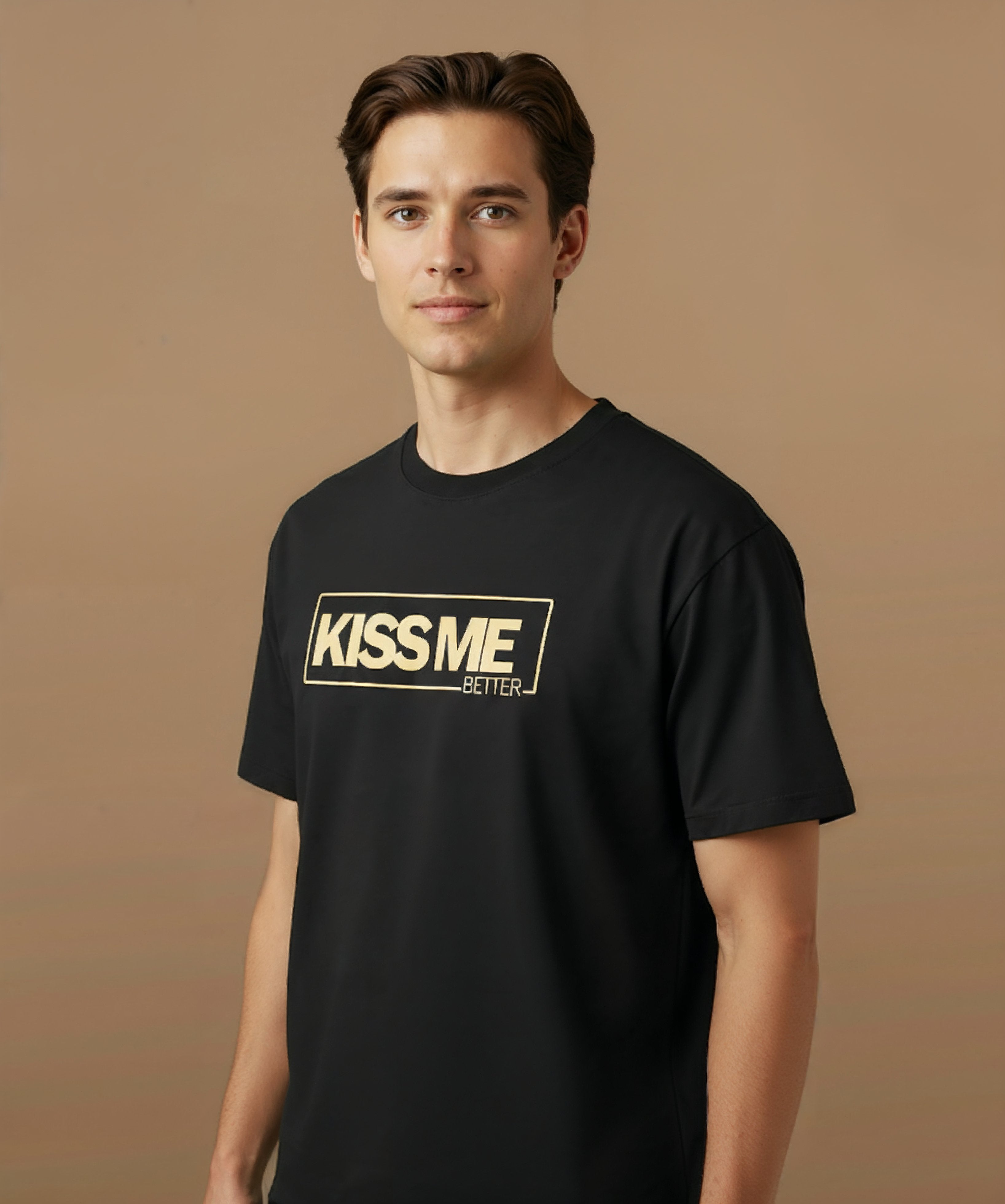 a male wearing a black t-shirt with 'KISS ME BETTER' text on a brown background, angled left