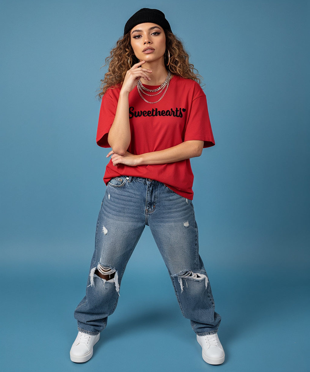 female wearing a red 'Sweetheart' shirt, blue jeans, and white sneakers on a blue background, front view