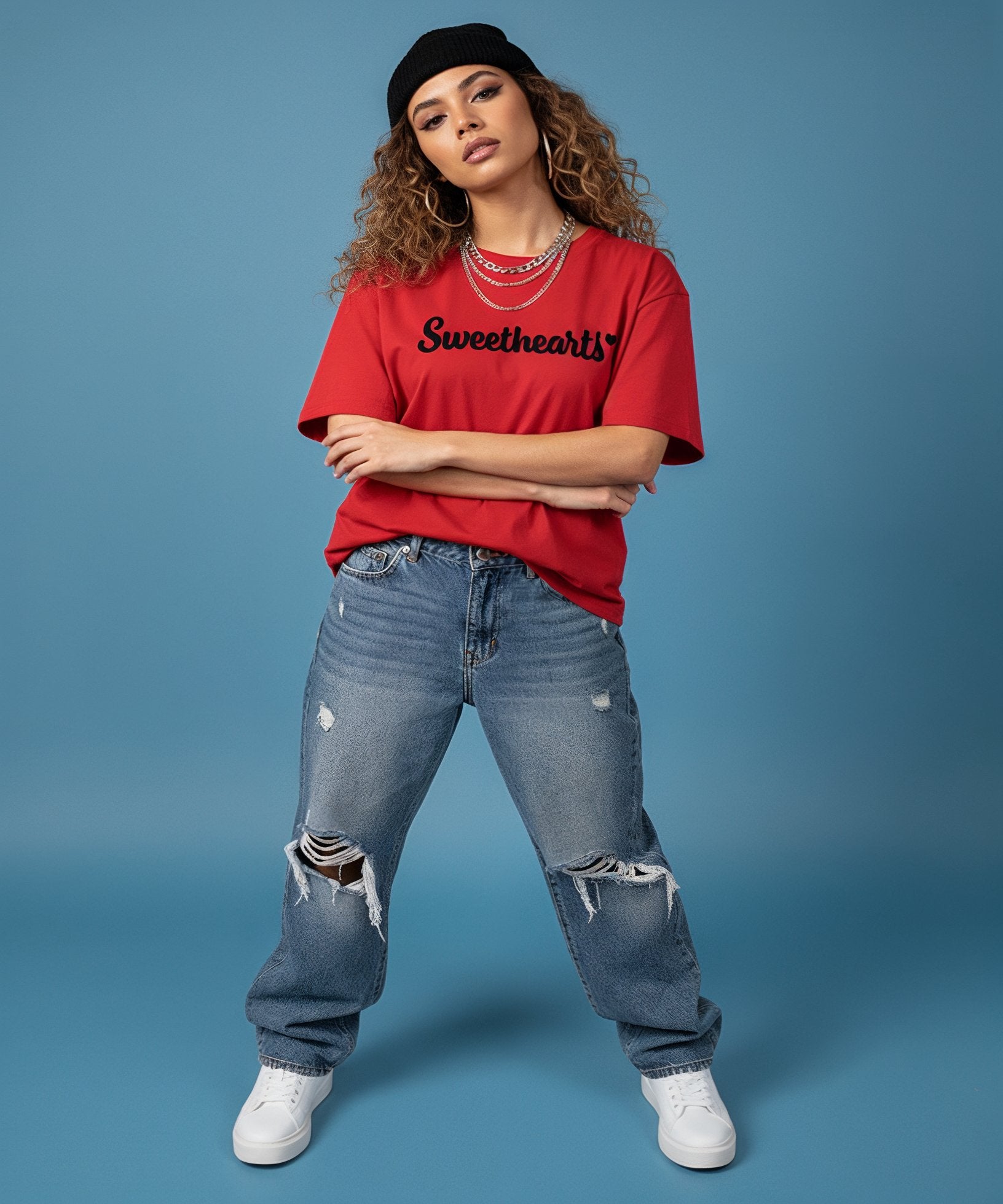 female wearing a red 'Sweetheart' shirt, blue jeans, and white sneakers on a blue background, front view