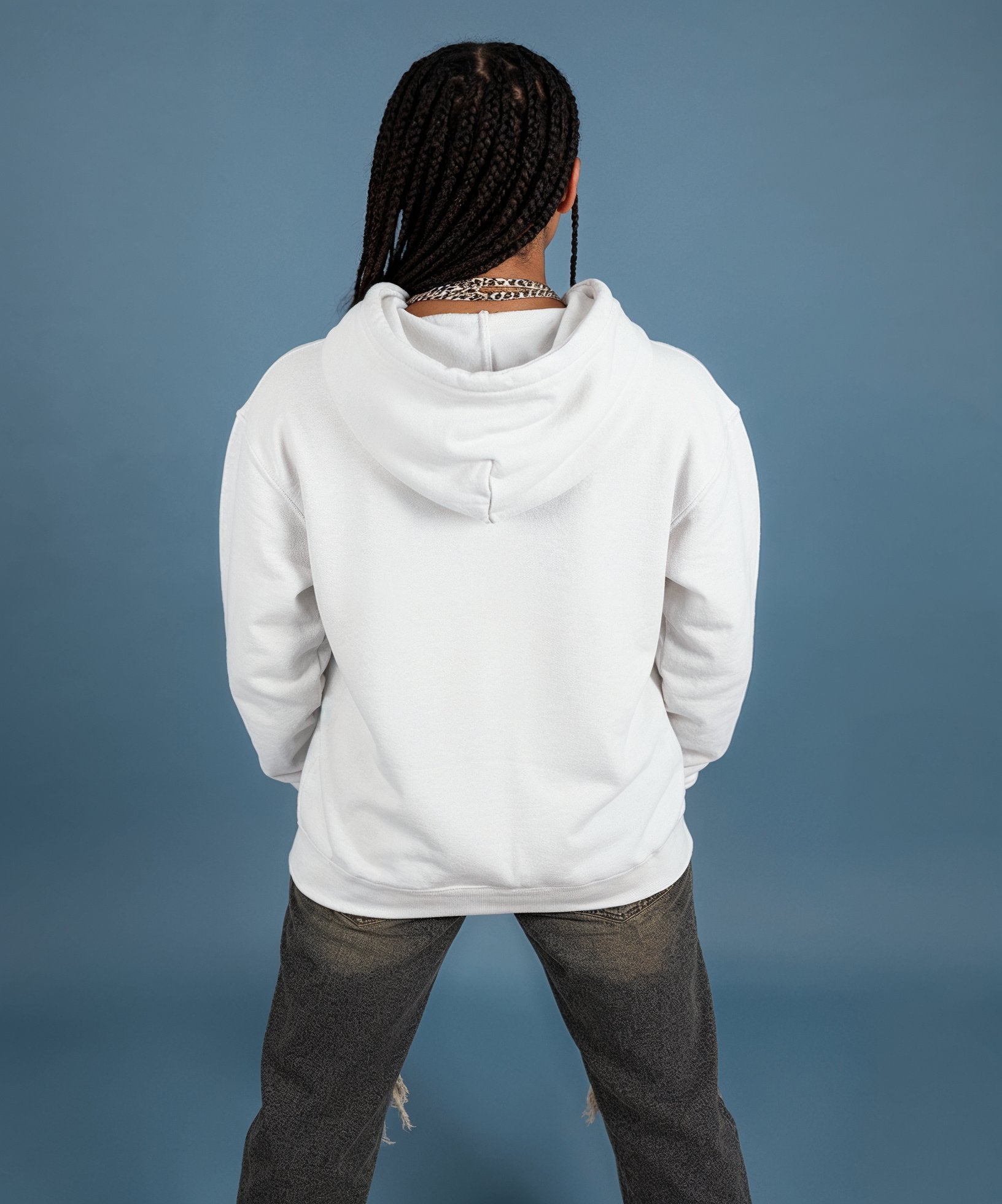 female wearing a white hoodie with a sweethearts red heart logo and xoxo design and text on a blue background, back view