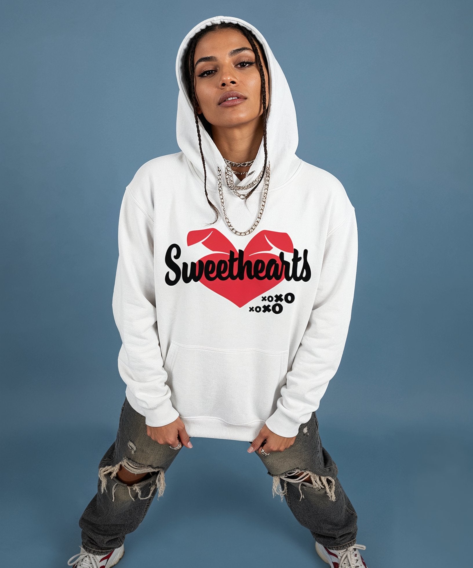 female wearing a white hoodie with a sweethearts red heart logo and xoxo design and text on a blue background