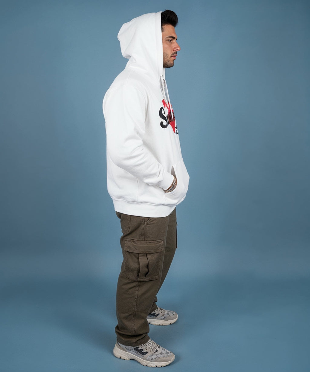 Man wearing a white hoodie with a sweethearts red heart logo and xoxo design and text on a blue background, side view
